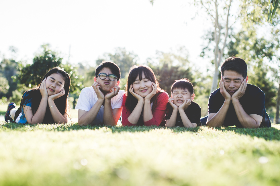 Family smiling while laying in grass